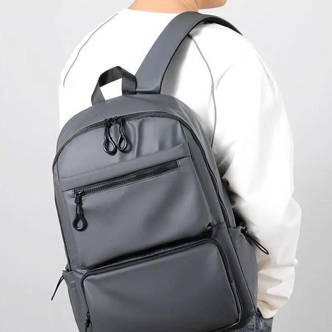 Hombre usando mochila urbana impermeable gris, estilo casual para ciudad