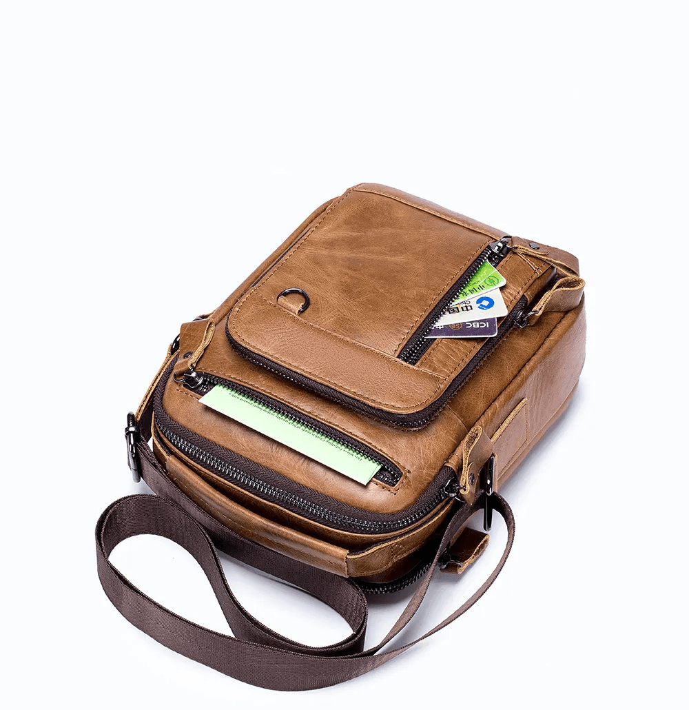 Bolsa crossbody masculina de cuero café con varios compartimentos y cierre.