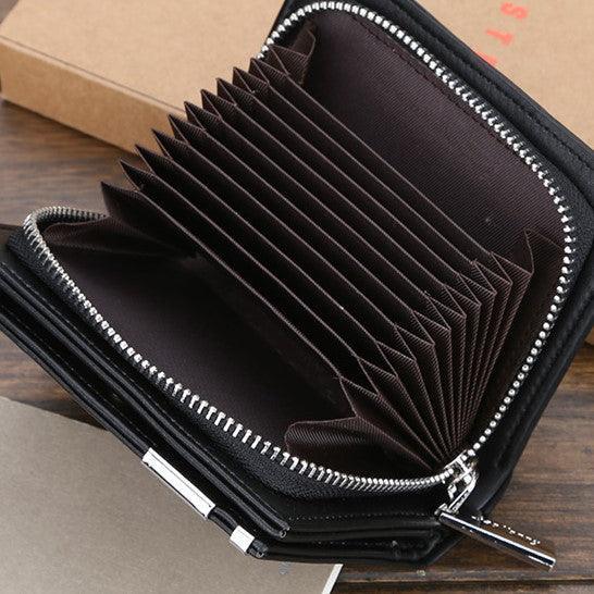 Cartera masculina de cuero negra con cremallera y múltiples compartimentos abierta sobre mesa