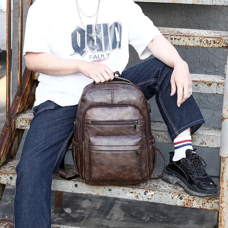 Mochila masculina de cuero marrón compacta con múltiples bolsillos sobre escalera urbana.