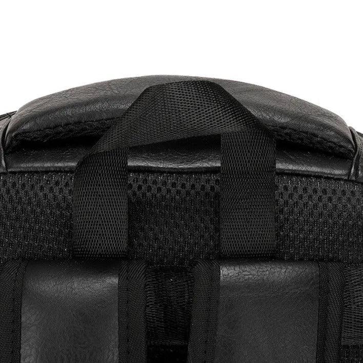 Detalle de mochila compacta de cuero negra para hombre con asa resistente y panel acolchonado